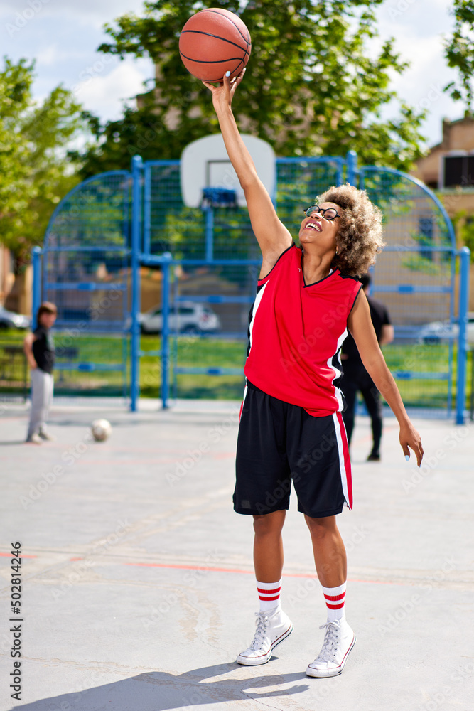 woman training outdoors on basketball court