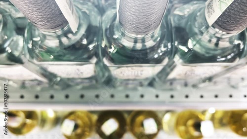 Rows of vodka bottles stand on the shelves of a liquor store (ABC store). Top view. Closeup photo