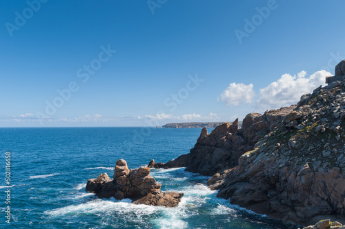 La cote déchiquetée de la region Bretagne avec les roches et l'ocean sous un ciel bleu à proximté de Concarneau en France photo