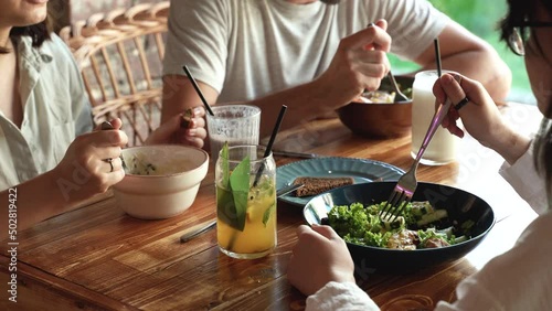 3 happy friends eating healthy food and enjoying in vegan cafe. Avocado salad. Pea puree soup. Salad with eggs and vegetables. Healthy food concept. 4k footage