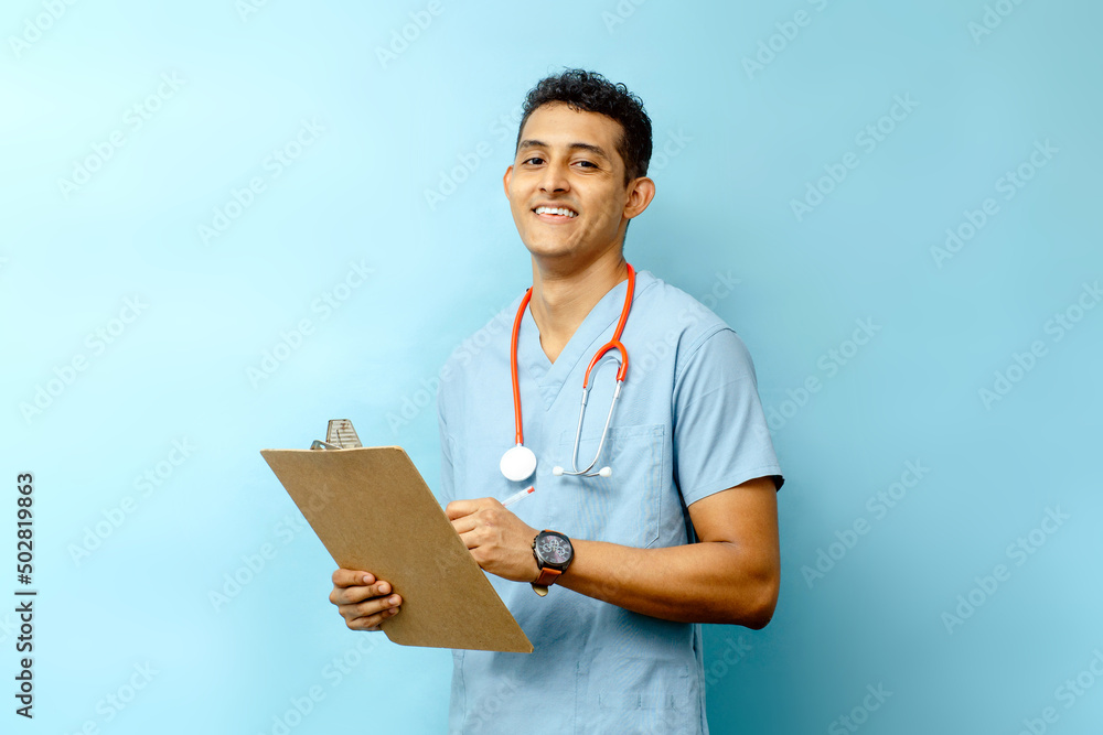 young latin american male assistant holding a medical chart and a pen. young latin american male assistant holding a medical chart and a pen.