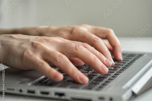 Hands typing on desktop keyboard