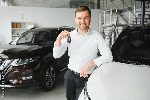 Happy man showing the key of his new car. photo