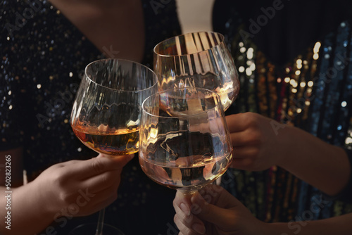 Women clinking glasses with white wine, closeup photo