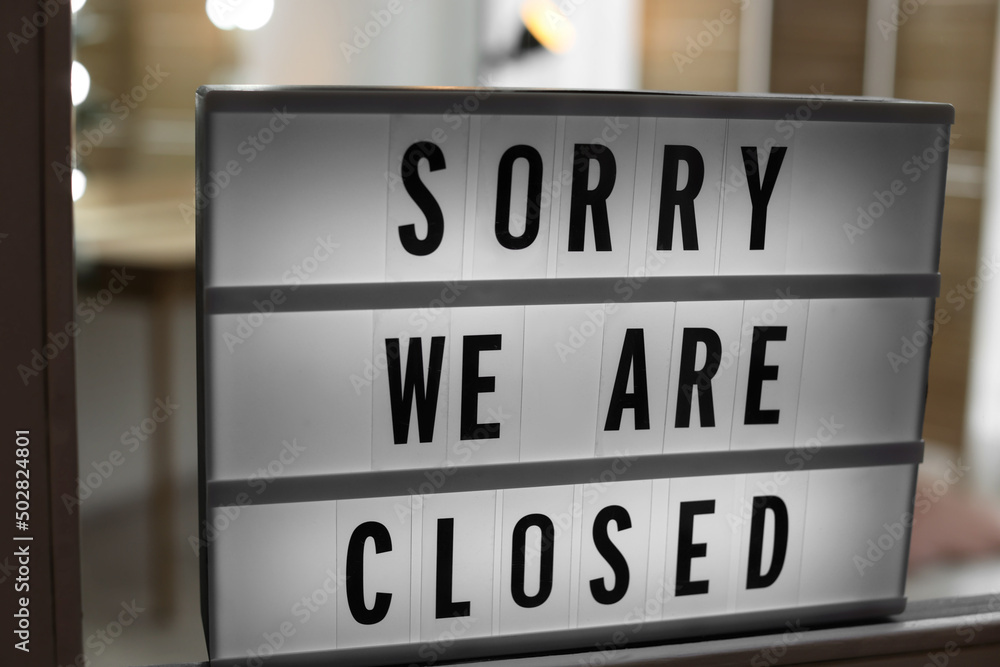 Lightbox with text SORRY WE ARE CLOSED hanging on glass door. Coronavirus quarantine Lightbox with text SORRY WE ARE CLOSED hanging on glass door. Coronavirus quarantine
