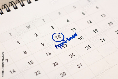 Blue circle marked with pen and writing Appointment on calendar.