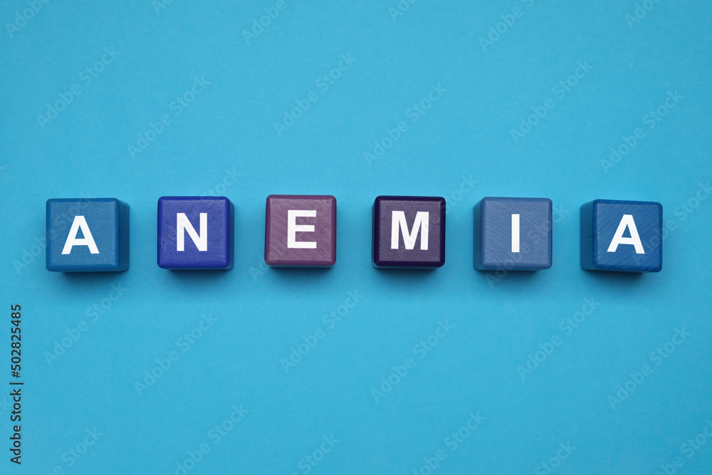 Wooden cubes with word Anemia on light blue background, flat lay Wooden cubes with word Anemia on light blue background, flat lay