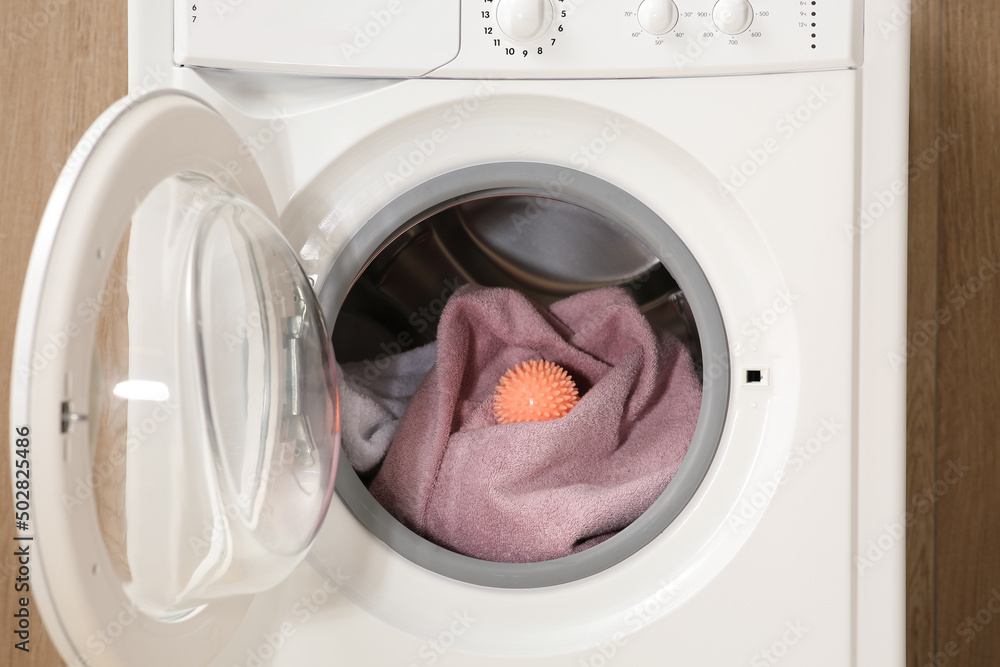 Dryer ball and towels in washing machine, closeup Dryer ball and towels in washing machine, closeup