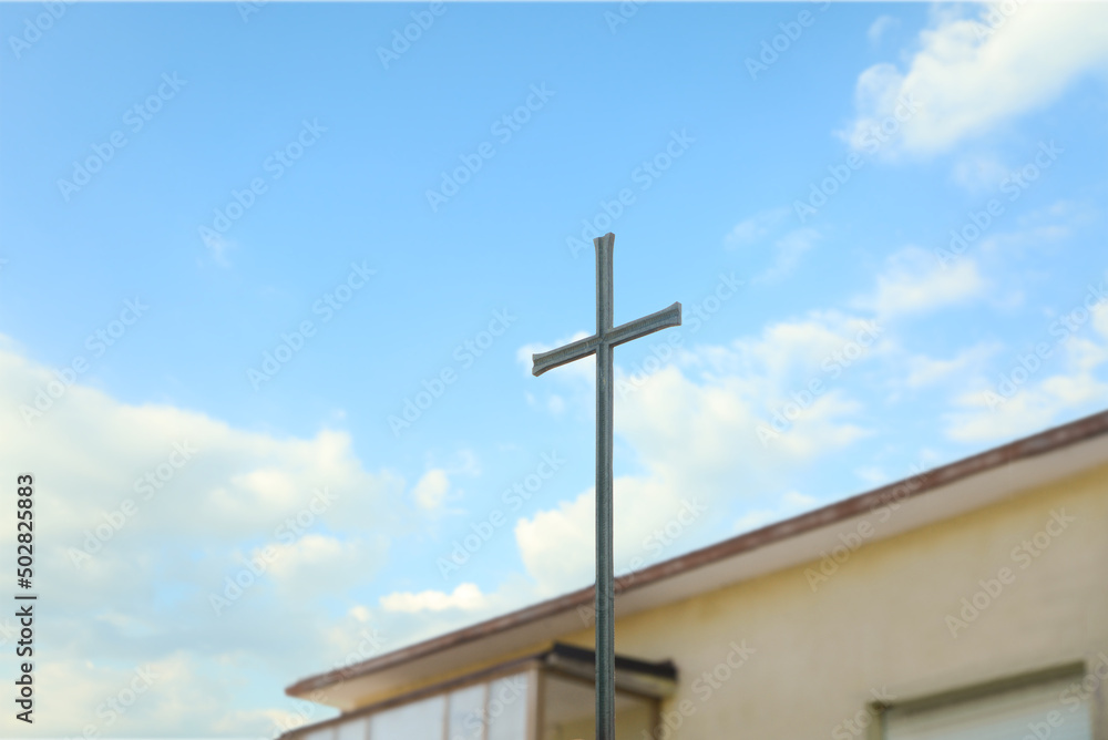 Metal Christian cross outdoors on sunny day