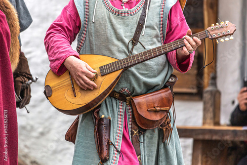 Close-up of medieval larp cosplay costumes, an unrecognizable person holding a medieval guitar photo