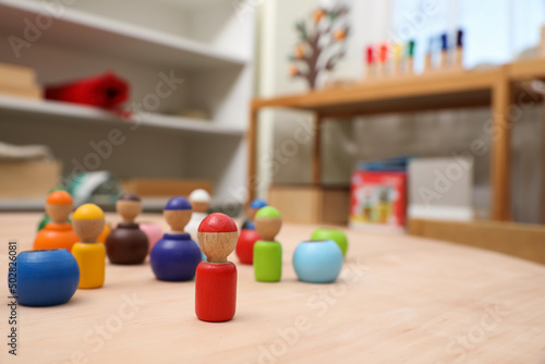Fototapet wooden colorful dolls shaped building blocks on table in room