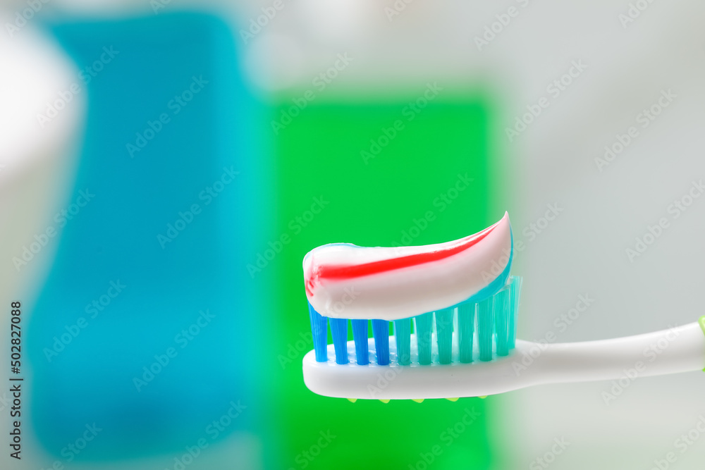 Toothbrush with paste against blurred background, closeup Toothbrush with paste against blurred background, closeup