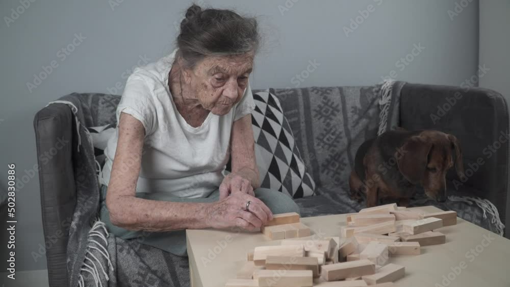 Senior woman 90 years playing with wooden blocks, cognitive training
