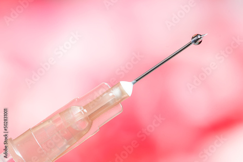 vaccine syringe with red-white background © halilakayy