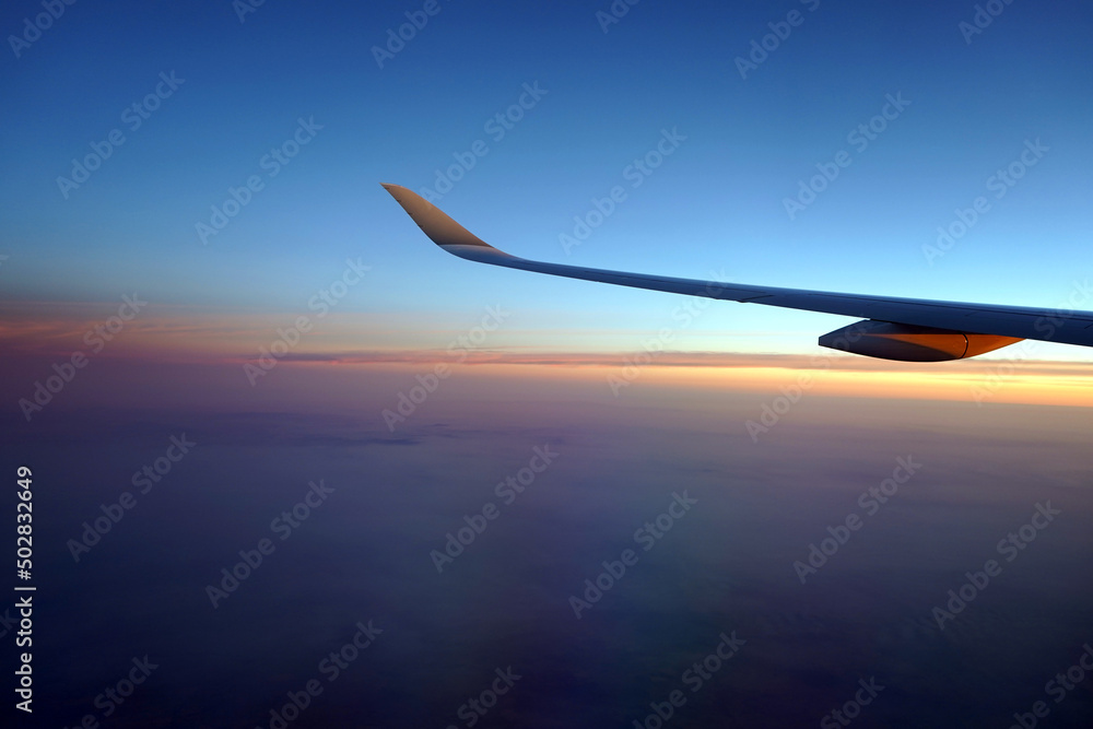 View of the airplane wing during sunset. View of the airplane wing during sunset.
