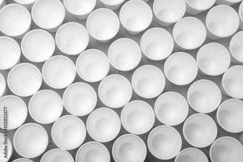 Many styrofoam cups on light grey background, flat lay