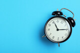 Alarm clock on light blue background, top view with space for text. School time