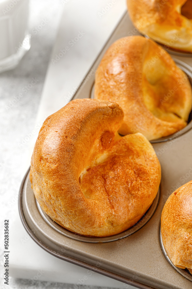English Yorkshire pudding in baking dish, in muffin cups close up. Homemade Traditional British food. English Yorkshire pudding in baking dish, in muffin cups close up. Homemade Traditional British food.