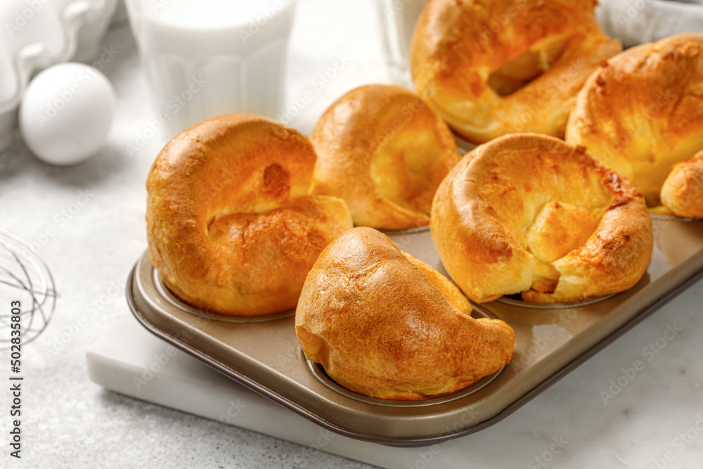 Yorkshire pudding in baking dish, in muffin cups. Homemade traditional English food. Grey background. Close up Yorkshire pudding in baking dish, in muffin cups. Homemade traditional English food. Grey background. Close up