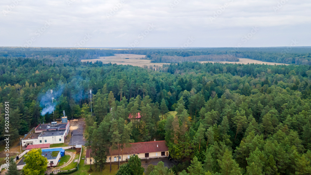 Aerial view of luxury hotel with villas in forest. Luxurious villa, pavilion in forest. Resort complex in forest surrounded by trees.