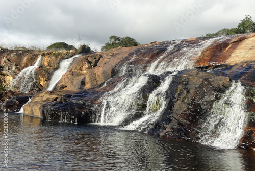 Linda Cachoeira entre pedras, com muita vegetação em volta e céu azul, localizada na região rural de Três Barras, município do Serro, Minas Gerais, Brasil.