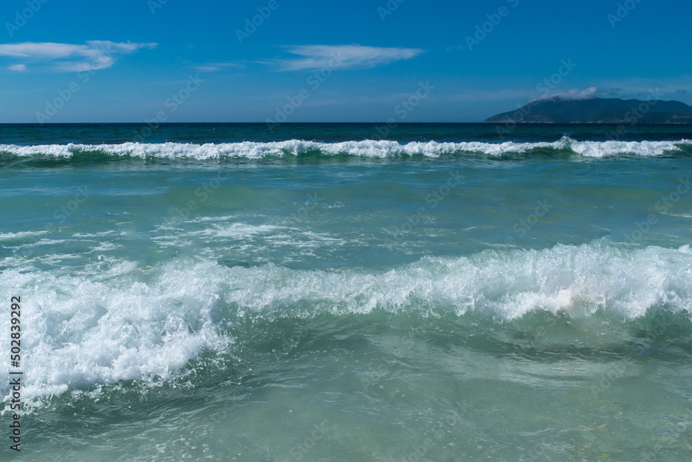 Lindas ondas em praia de areias brancas, céu azul e montanhas, localizada na região de Cabo Frio, Rio de Janeiro, Brasil. (2)