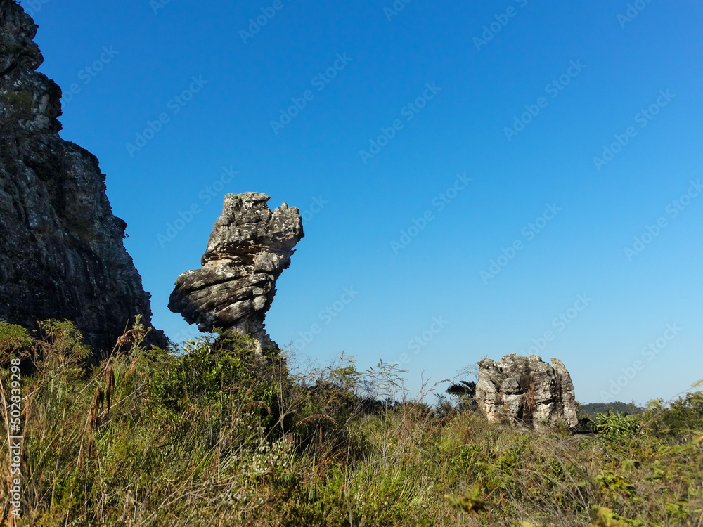 Lindas pedras em montanha, com vegetação baixa e céu azul, localizada na região rural de Três Barras, município do Serro, Minas Gerais, Brasil.