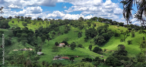 Vista de fazenda, com algumas construções, muita vegetação e montanhas ao redor, localizada na região rural do bairro Jardim das Oliveiras, município de Esmeraldas, Minas Gerais, Brasil.