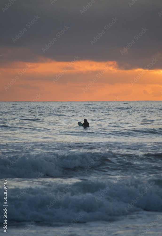 silhouette of a surfer in the sea