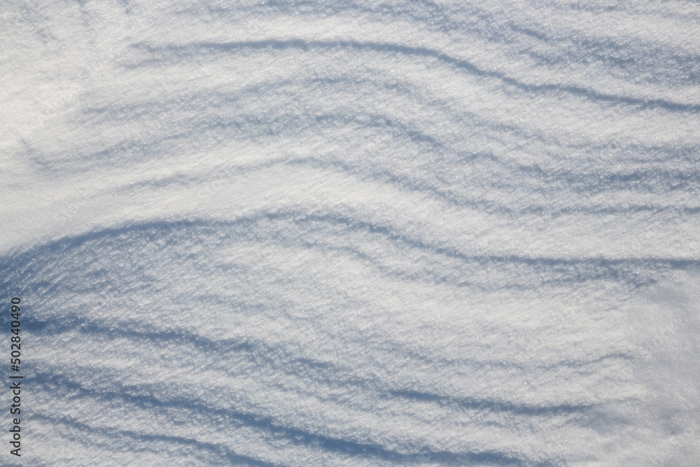 Beautiful winter background with snowy ground. Natural snow texture. Wind sculpted patterns on snow surface. Beautiful winter background with snowy ground. Natural snow texture. Wind sculpted patterns on snow surface.