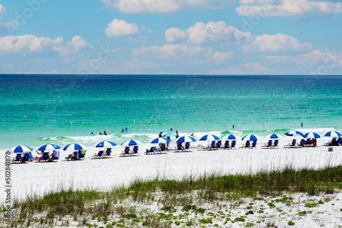Blue and white beach umbrellas on shore of Navarre Beach, Florida photo