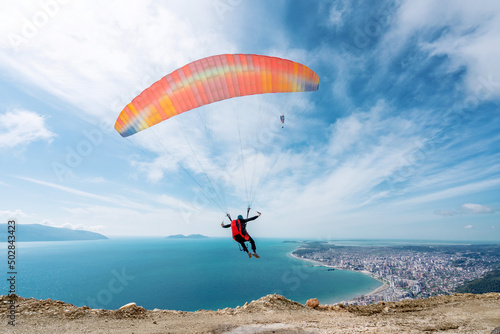 Paraglider is starting. Parachute is filling with air in the mountains alps on a sunny day in albania