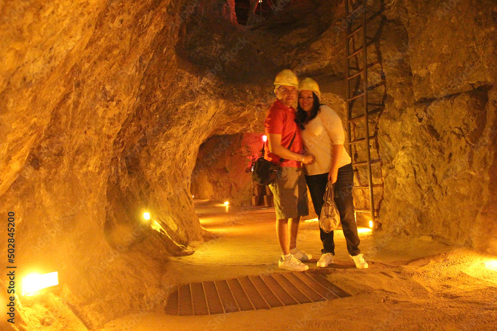 Couple man and woman explore a silver mine in the city of Zacatecas Mexico with yellow helmets enjoy their weekend vacations walking
