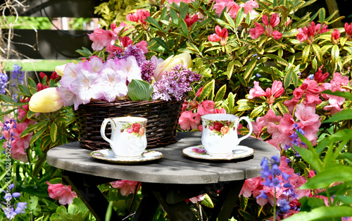 Spring garden afternoon tea with lilacs and tulip bouquet in beautiful garden setting