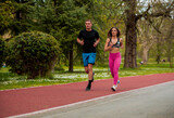 Cute sporty couple in sporty outfit working out and running together outdoors