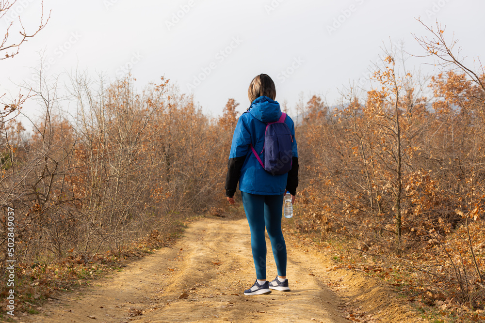 Fototapeta premium Standing alone and smiling while preparing for her training in the forest