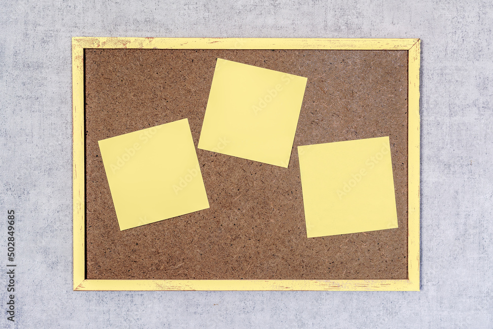 Trois post-it jaunes sur petit tableau en bois Trois post-it jaunes sur petit tableau en bois