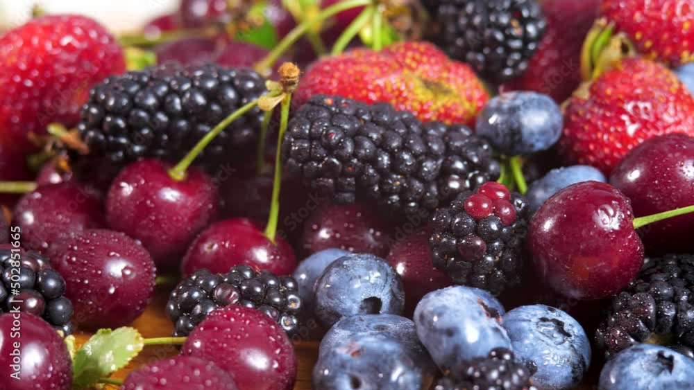 Water drops on heap of fresh forest berry. Raw strawberry, dark cherry, organic blueberries, yummy mulberries Water drops on heap of fresh forest berry. Raw strawberry, dark cherry, organic blueberries, yummy mulberries