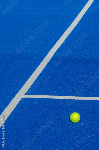 blue paddle tennis court, a solitary ball close to the baseline © Vic