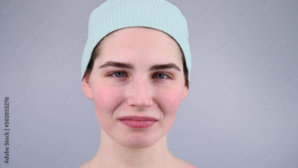 Close-up portrait of a young woman massaging her face with a gouache scraper. Close-up portrait of a young woman massaging her face with a gouache scraper.