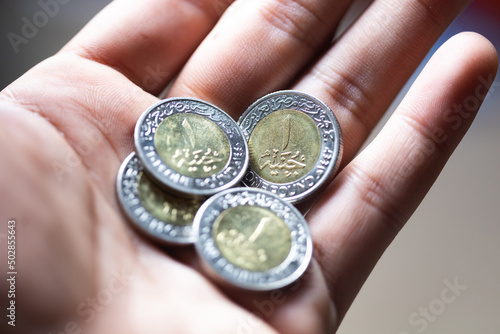 Egyptian coins currency in the palm of a man's hand 