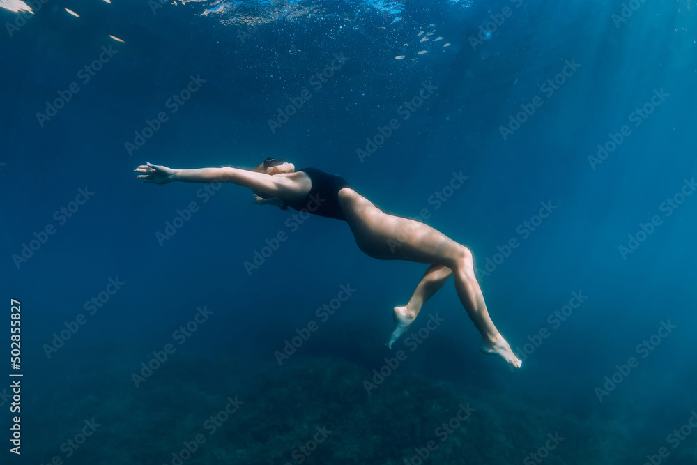 Woman posing underwater in blue ocean. Beautiful lady in bikini undewater Woman posing underwater in blue ocean. Beautiful lady in bikini undewater