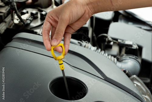 hand hold engine oil check rod for look level of oil follow standard car manual before traveling.Car care concept.