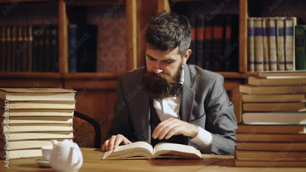 Reader and intelligence concept. Man enjoys book and has coffee or tea. Businessman in classic suit read book. Old fashion business people. Reader and intelligence concept. Man enjoys book and has coffee or tea. Businessman in classic suit read book. Old fashion business people.