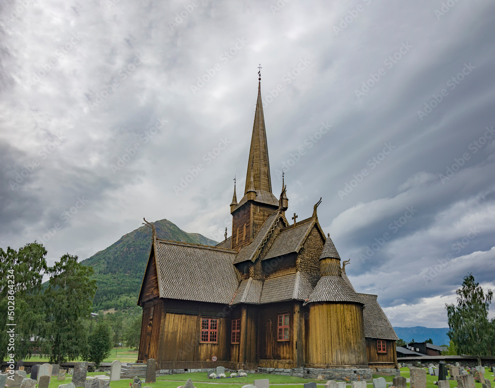 Dramatic clouds in the sky above the Lom medieval wooden viking age stave church in Lom, Norway
