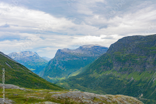 Norwegian summer landscape. Green and grey rocky mountains  mossy stones  cloudy sky
