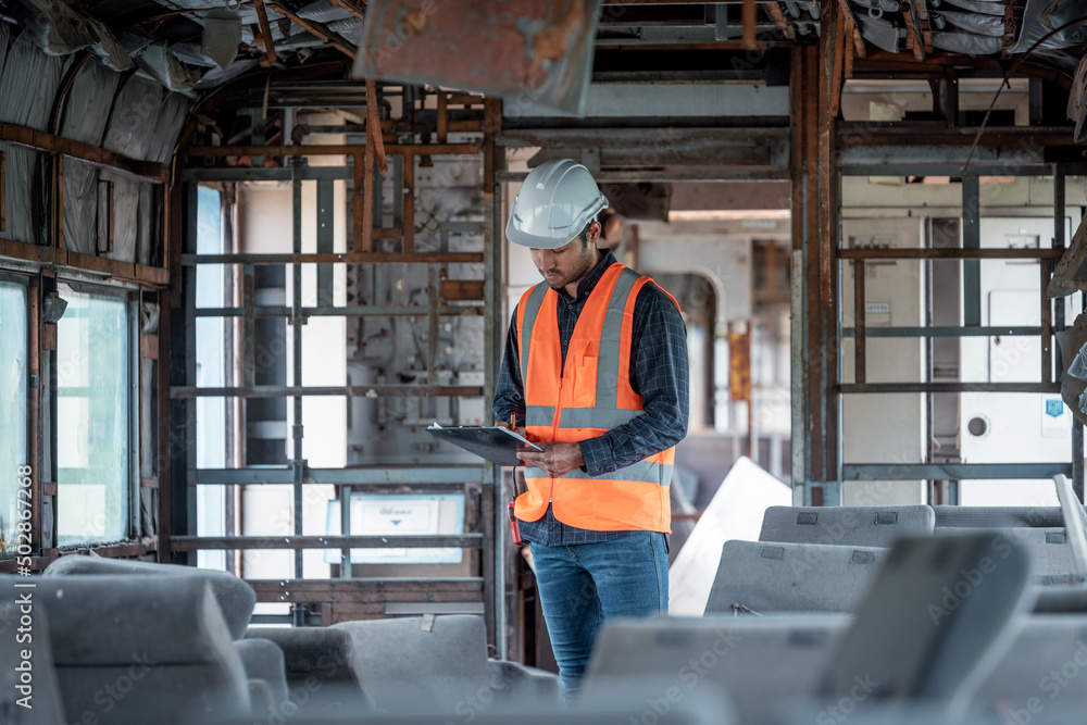 Engineer under inspection and checking construction process railway switch and checking work on railroad station .Engineer wearing safety uniform and safety helmet in work.	