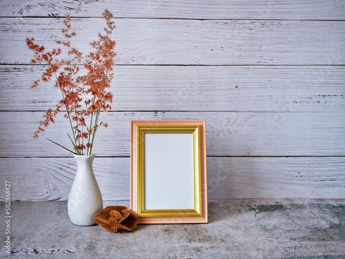 Rose Red Natal Grass flowers in vase on table vintage background ,copy space for letter ,Melinis repens Willd white vase old wall ,Empty photo frame ,black and white, gray color photo