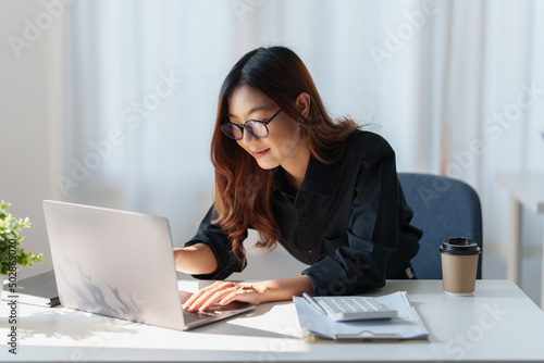 Charming Asian Business Woman working at office. Account and finance concept.