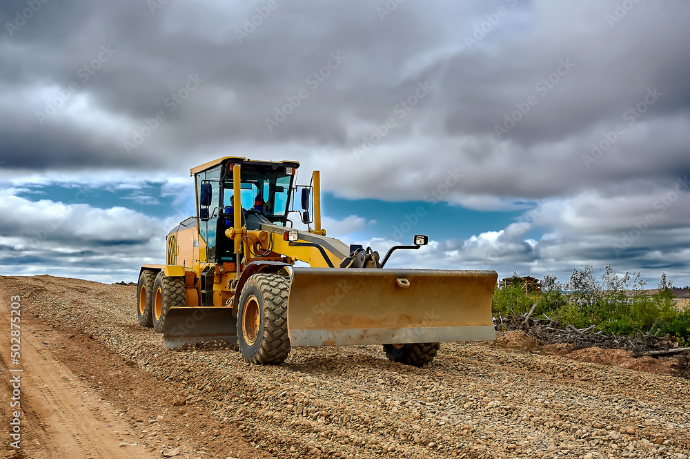 Fototapeta premium a grader on the construction site levels the rubble